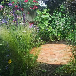 a garden with a brick walkway surrounded by flowers