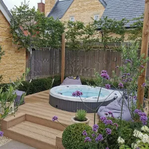 A garden with a hot tub in the middle of it.