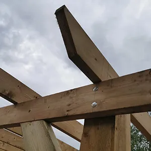 A close up of a wooden structure under a cloudy sky.