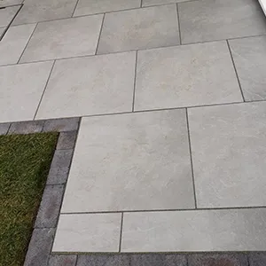 A dog is sitting on a bench outside.