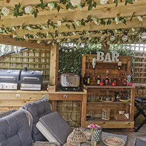 A patio with a couch, table, chairs and a bar.